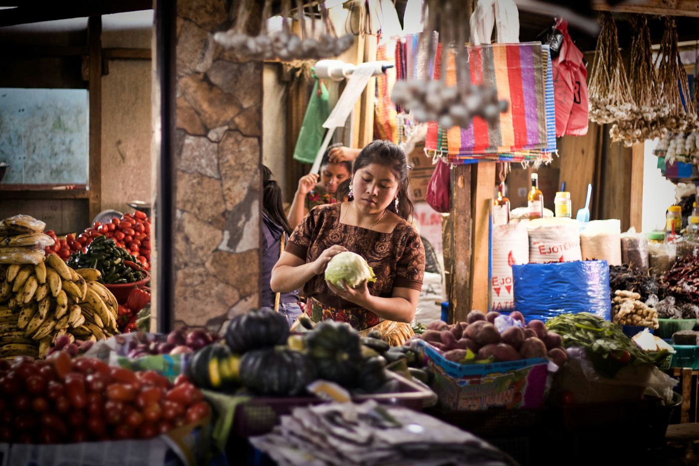 Vendedora en su puesto de un mercado, como foto de portada de un perfil de negocio