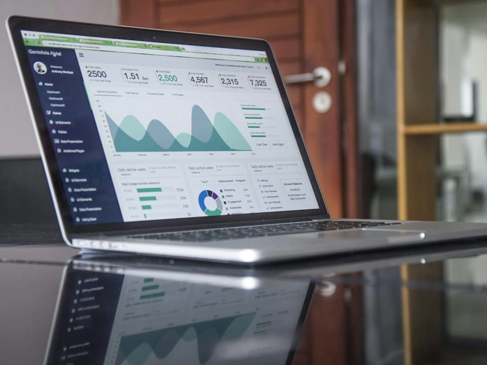 Laptop mostrando un panel de analítica web con gráficas de tráfico