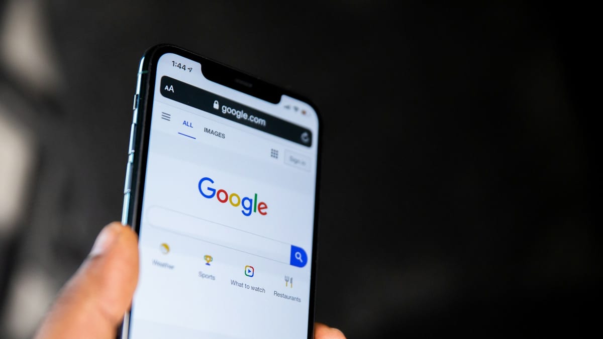 Mano sosteniendo un teléfono con la página de inicio de Google abierta